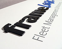 szyld firmowy tabliczka reklamowa wypukłe czarne litery o gr. 3 mm na białym laierowanym aluminium