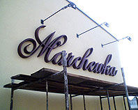 Brązowe litery ze styroduru podświetlone halogenami dla firmy Marchewka
