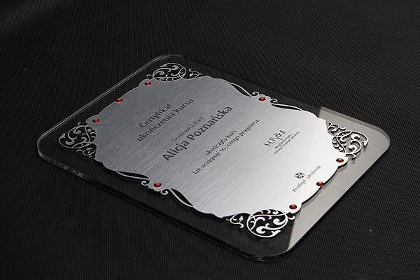 Certyfikat wycięty ze srebrnego szczotkowanego laminatu 
na podkładzie z bezbarwnej plexi, Romiar ok. 20 x 30 cm