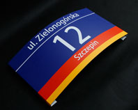 Aluminiowa tablica adresowa 
zaginana po łuku 
z numerem nazwą ulicy i dzielnicy 
we Wrocławiu